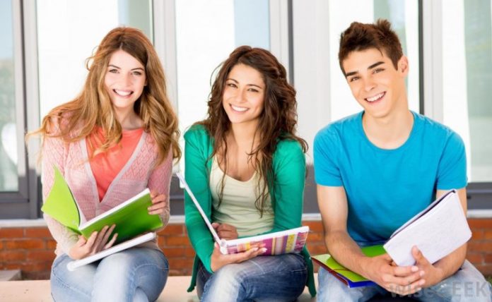 two-girls-and-one-boy-student-smiling-with-notebooks