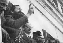 Απόγονοι δοσίλογων και ρουφιάνων των ναζί κυβερνούν την Ελλάδα Ο μπαμπάς του Σημίτη εκ δεξιών του Άρη Βελουχιώτη την ώρα που αυτός έβγαζε το γνωστό του λόγο στη Λαμία. Από τραπεζίτης αρχικομμουνιστής! Ο Άρης αποκεφαλίστηκε, ο Γεώργιος μεγαλούργησε οικονομικά και ο υιός του διέλυσε τη χώρα